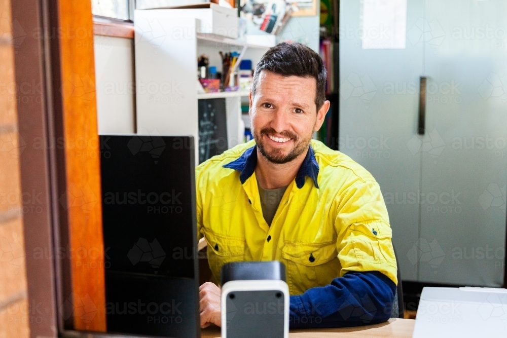 Short Term Business Loans 3 happy male tradie at computer in home office austockphoto 000101714